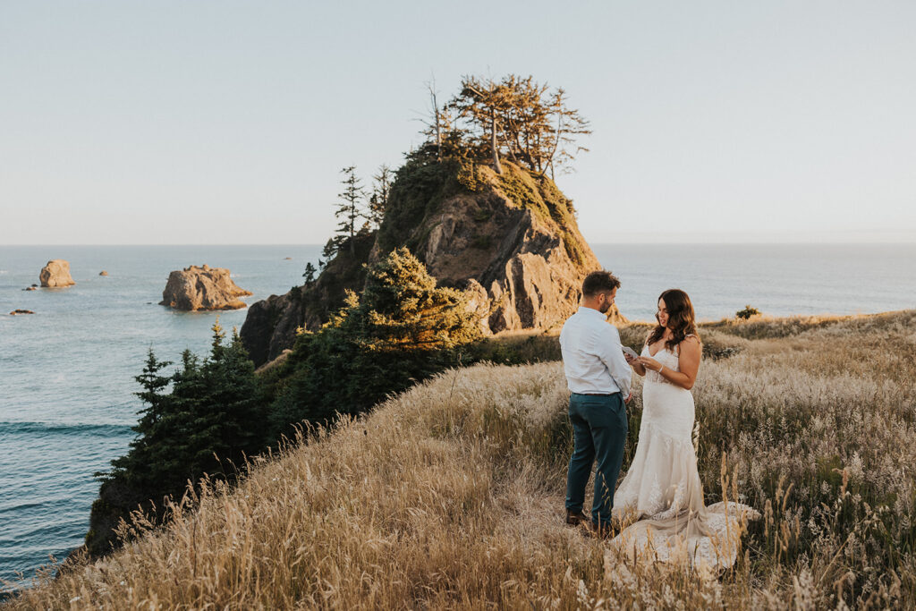 A couple in wedding attire exchanging vows on an ocean bluff on the Oregon Coast