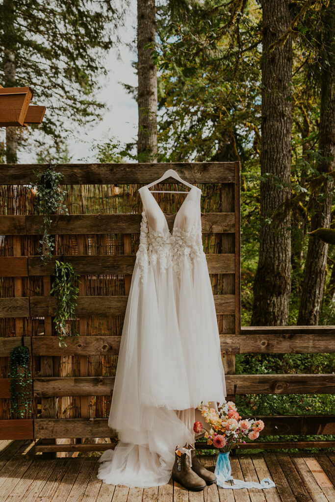 Wedding dress hanging up outside a vacation rental with a forest in the background 