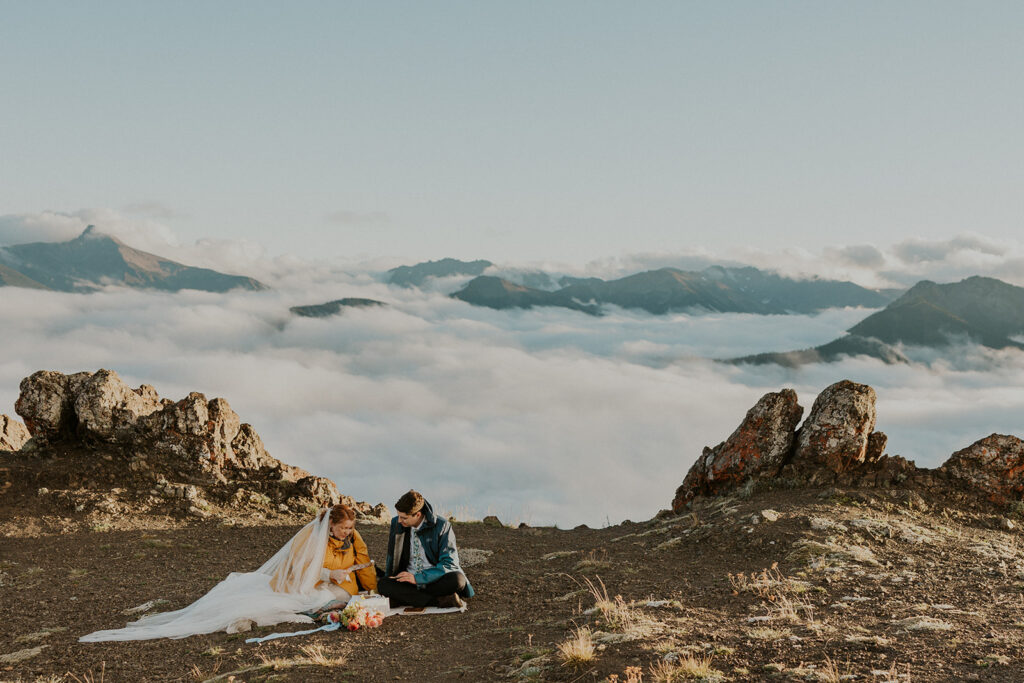 A couple in wedding attire read letters at Hurricane Ridge in Olympic National Park