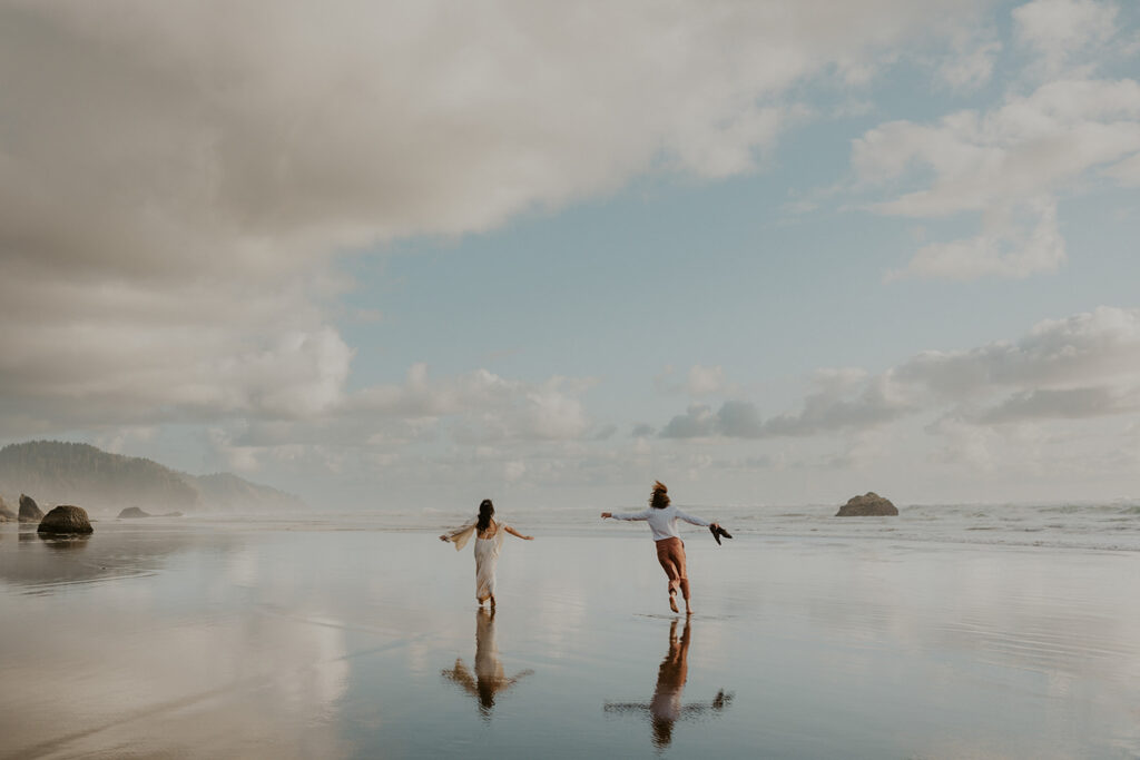 A wedding couple running on an Oregon Coast beach 