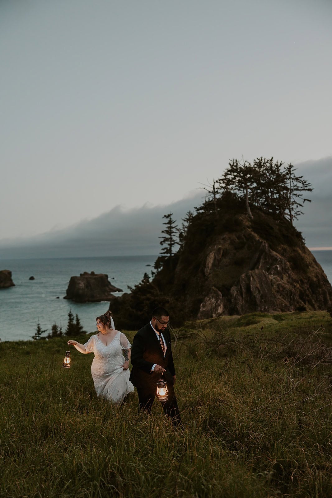A couple hiking with lanterns during their Oregon Coast elopement