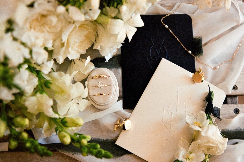 Flay lay for micro wedding featuring rings, vow books, jewelry, and bouquet on 35mm film