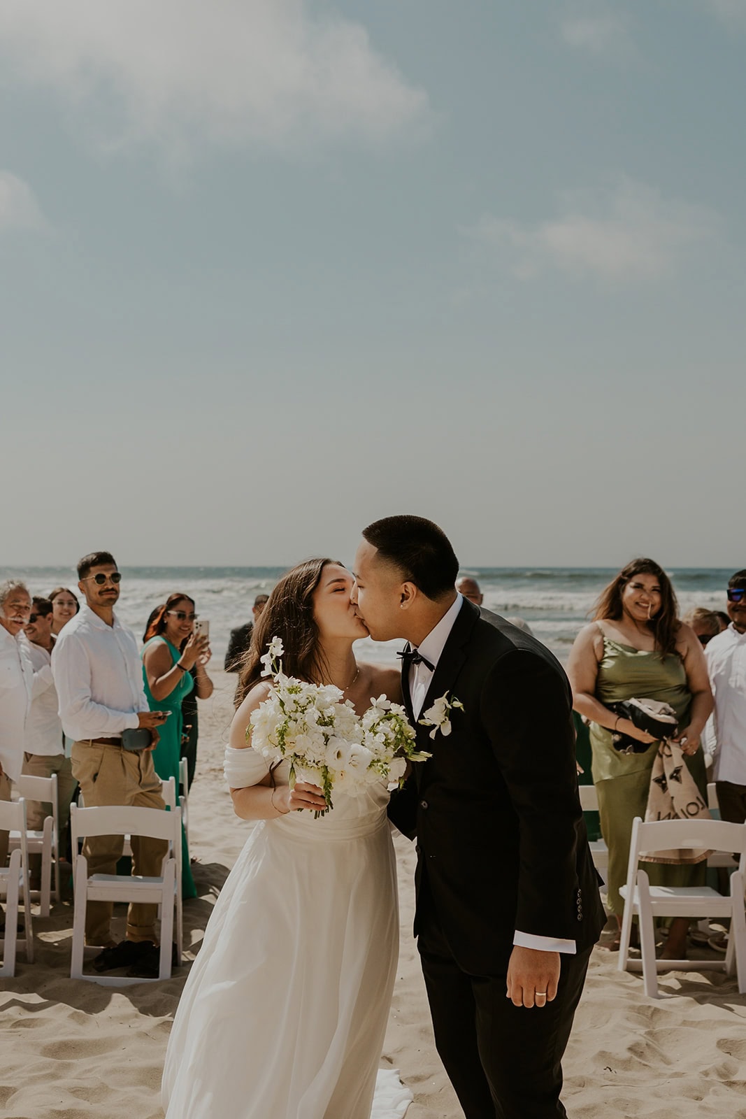Couple kissing while walking down the aisle during their micro wedding on the Oregon Coast
