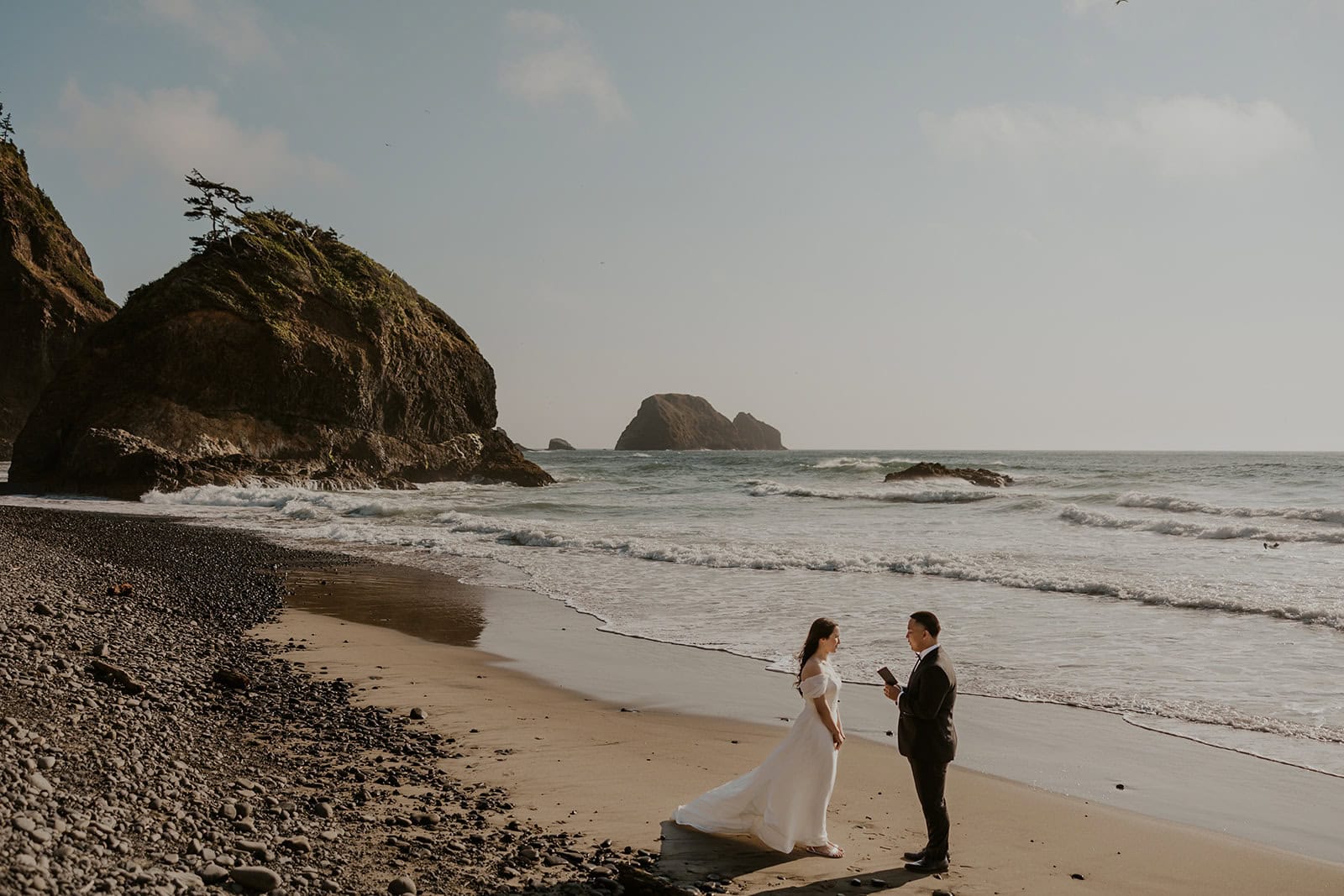 Couple in wedding attire exchanging vows on the Oregon Coast