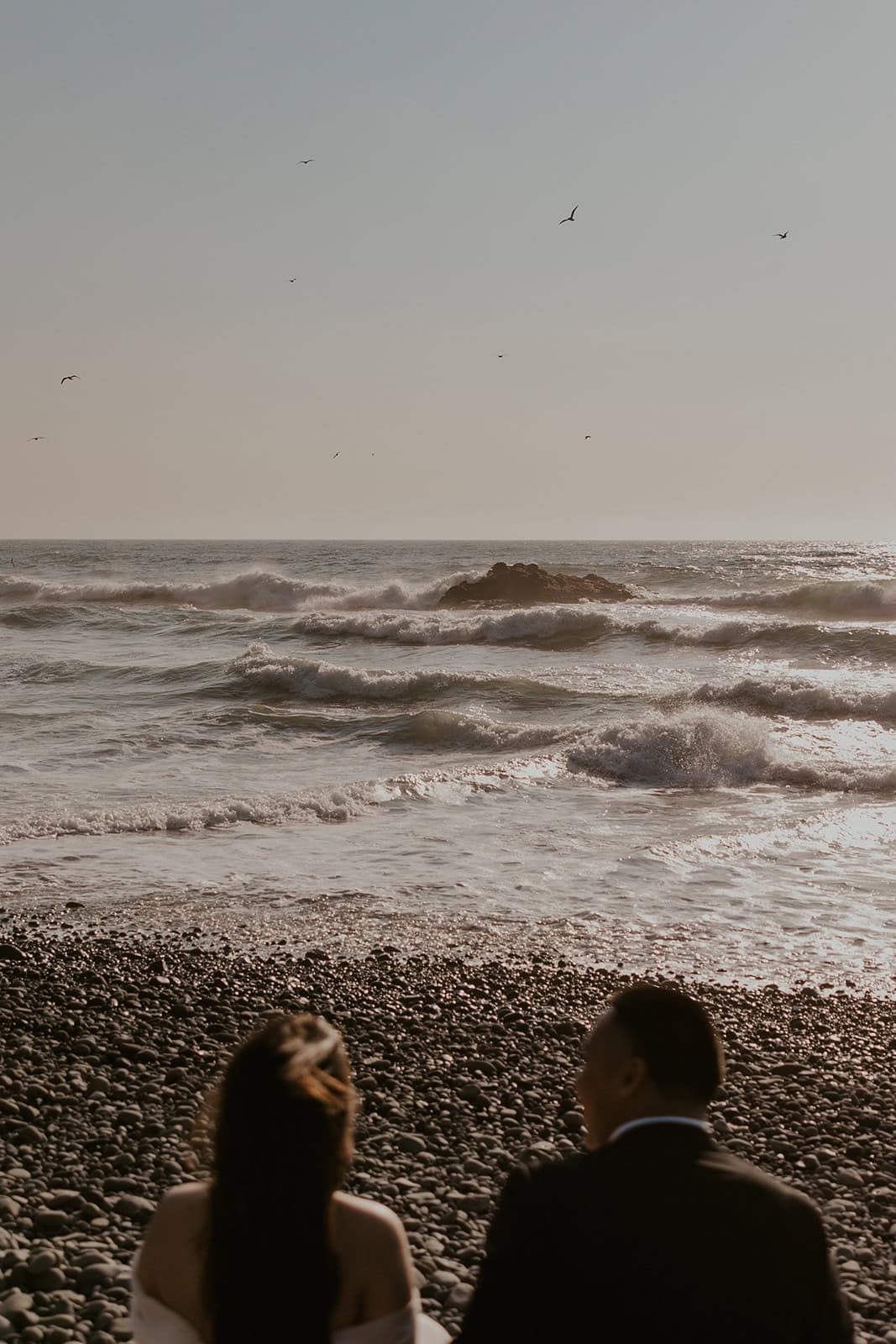 Couple watching ocean waves during their elopement day on the Oregon Coast