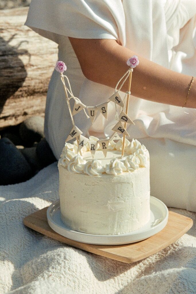 Wedding cake on the beach with "just married" sign on top on 35mm film