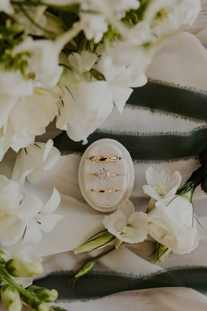 Flat lay with couple's wedding rings and wedding flowers