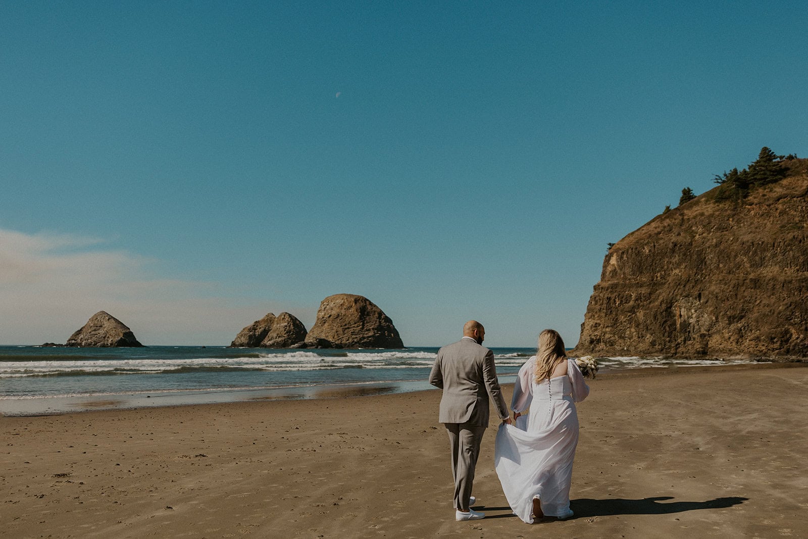 A couple walking on the beach during their elopement day on the Oregon Coast