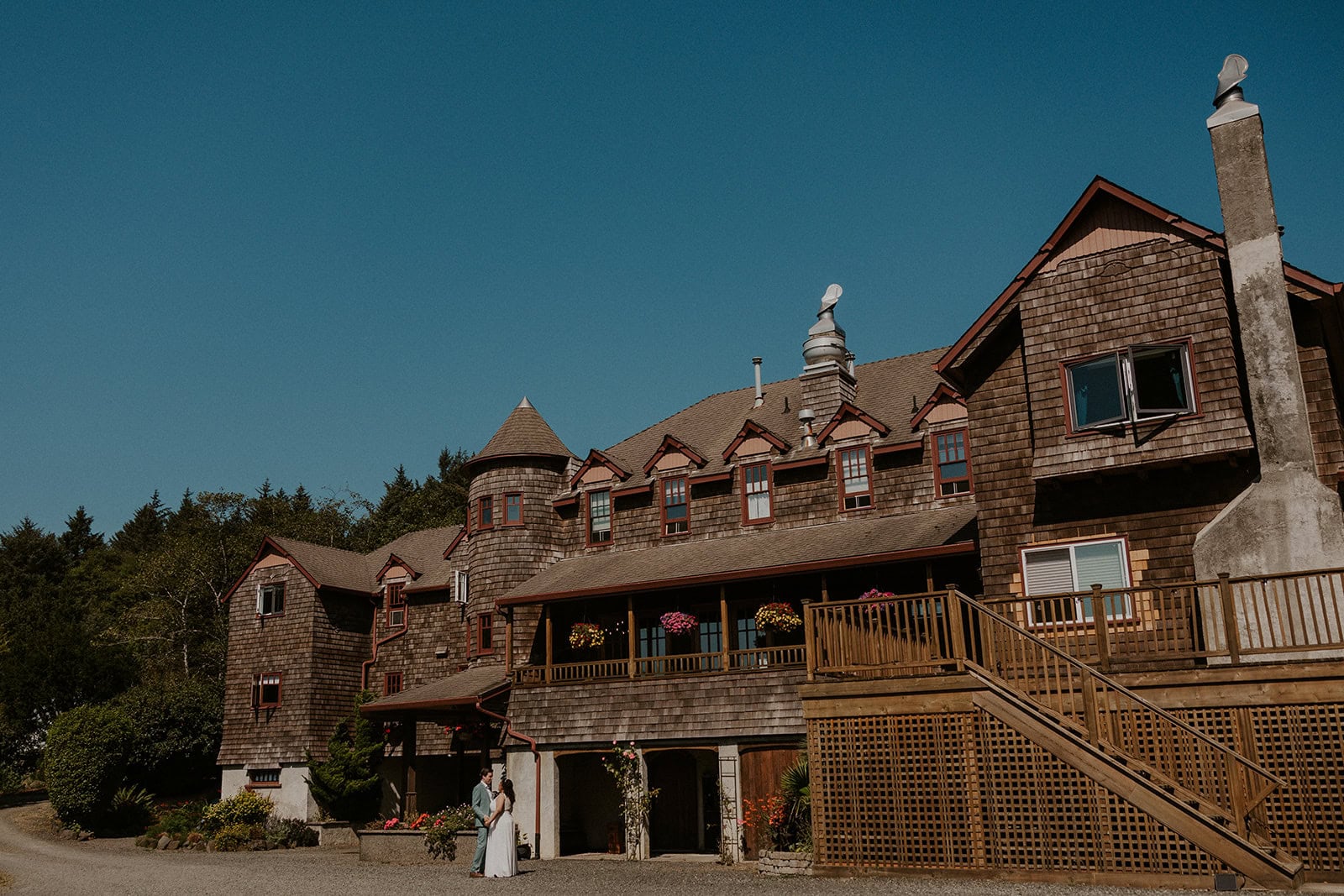 An eloping couple stands in front of Arch Cape Inn in Cannon Beach, OR