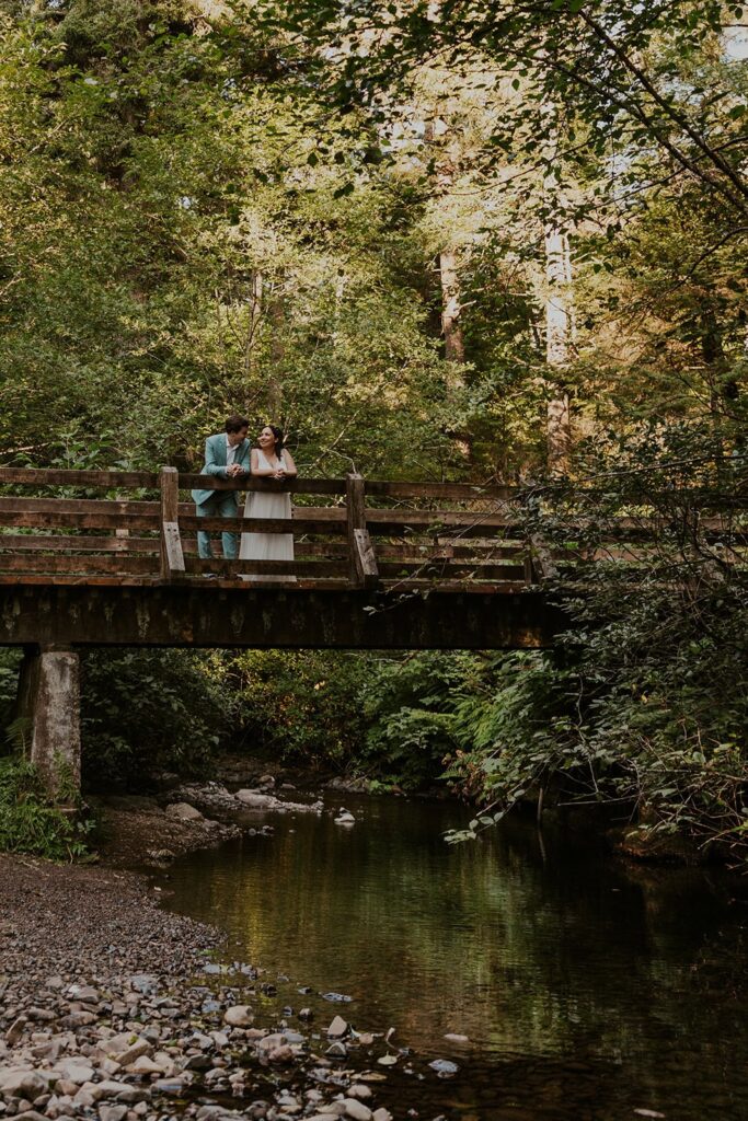 A couple standing on a wooden bridge over a creek at Short Sand Beach on the Oregon Coast during their elopement day