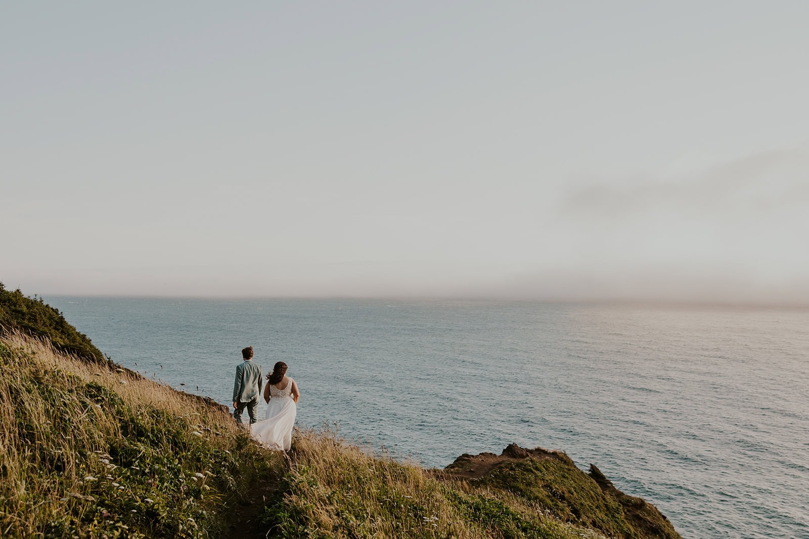 A couple hiking on their elopement day on the Oregon Coast