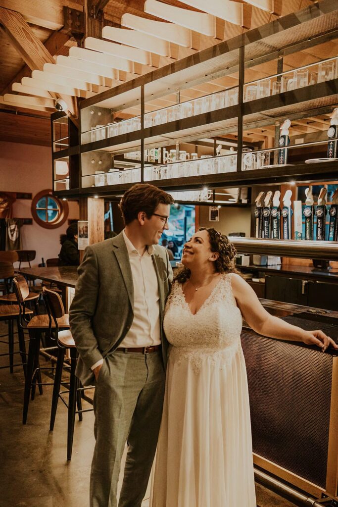 A couple having drinks together at Pelican Brewing in Cannon Beach during their elopement day