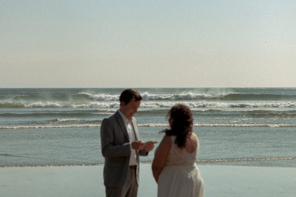 A couple exchanging vows at Short Sand Beach on the Oregon Coast during their elopement day on 35mm film