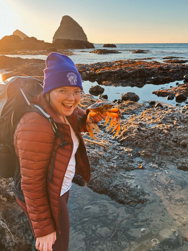Miki of Venturing Vows holding a Dungeness crab at an Oregon Coast tide pool