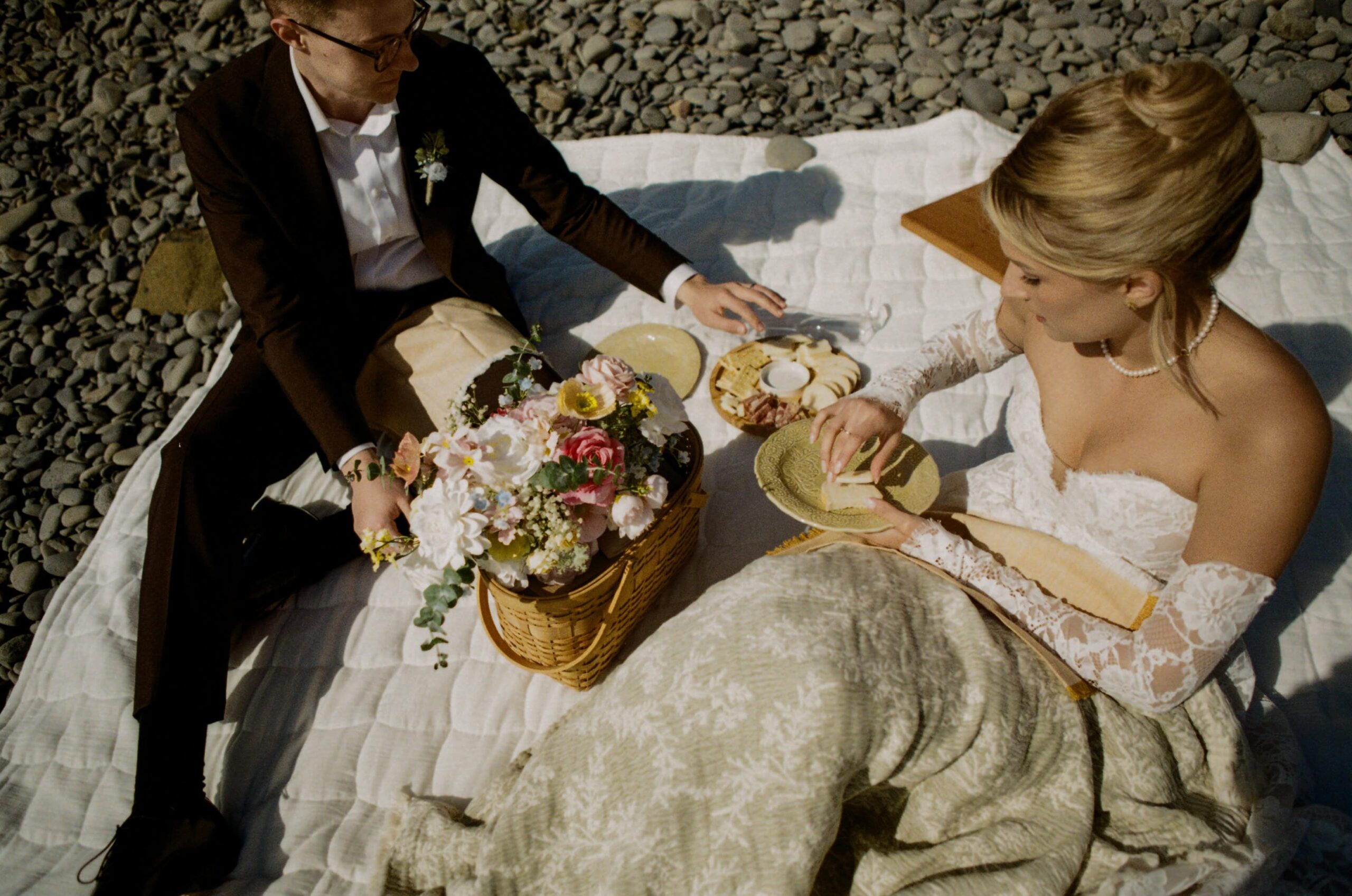 A couple shares a beach picnic during their elopement day on the Oregon Coast on 35mm film