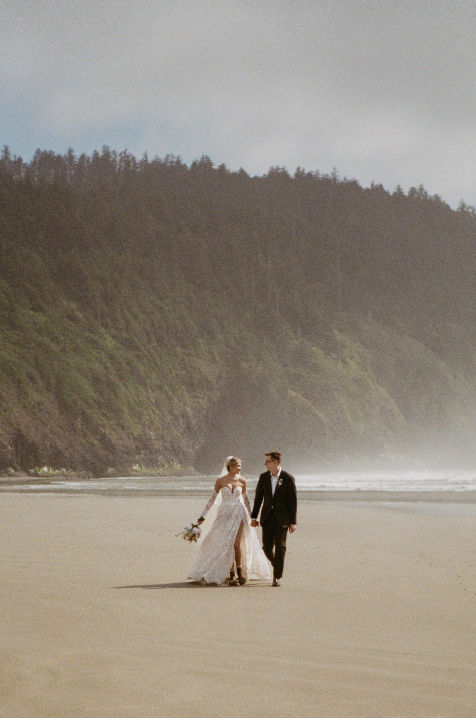 A couple walking on the beach during their elopement day, captured on film