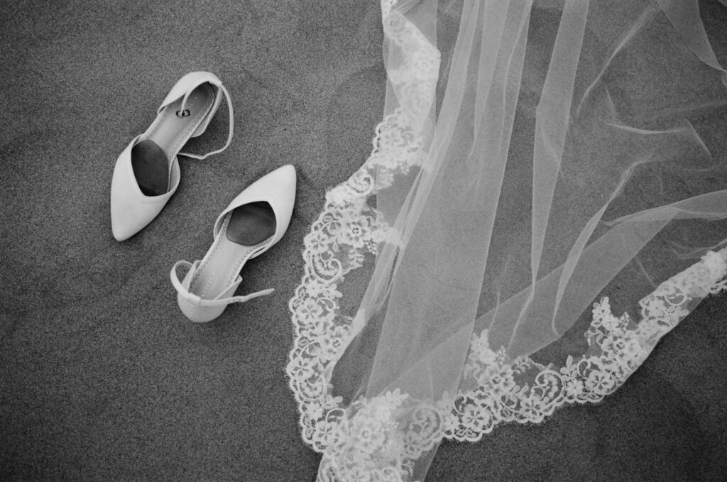 Bride's heels and veil on the sand during an Oregon Coast elopement on 35mm film