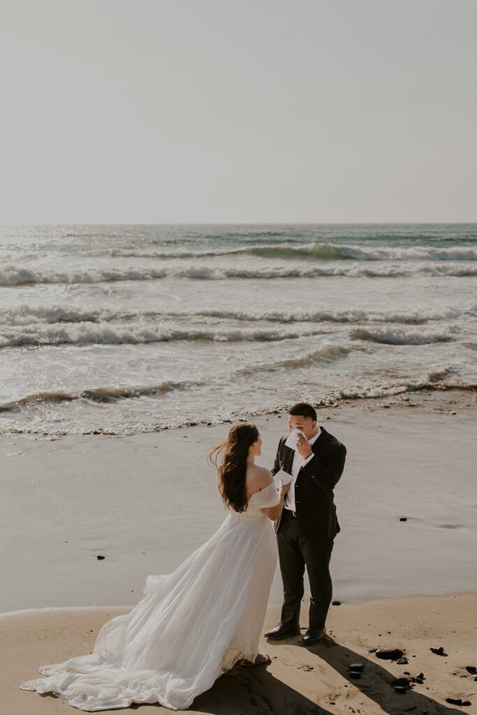 A couple exchanging vows on an Oregon Coast beach during their elopement